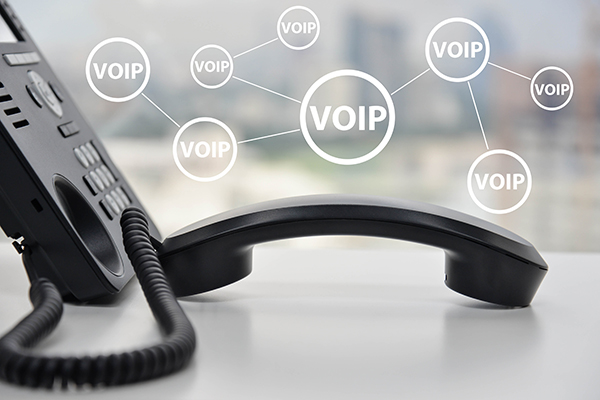 A phone sits off the hook with many small “VoIP” symbols hovering over it